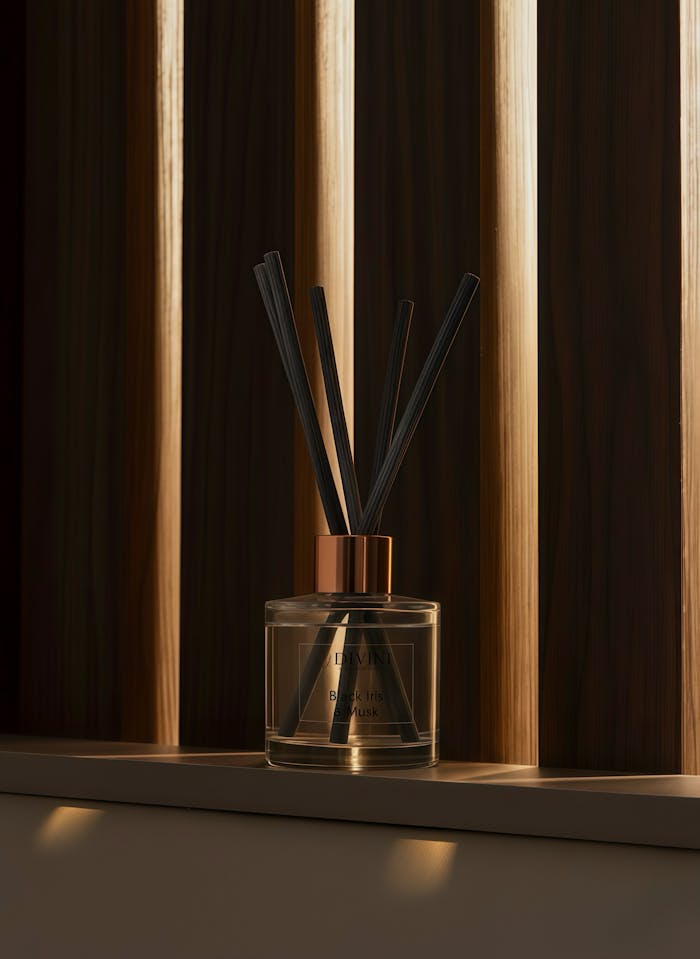 Glass perfume diffuser against a stylish wooden backdrop, creating a warm ambiance.